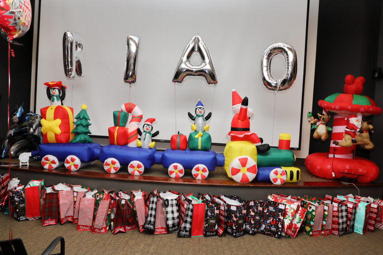 Inflatable train with Santa and penguins with gifts and balloons spelling out RIAO (Rubin Institute for Advanced Orthopedics) at the International Center for Limb Lengthening pediatric holiday party