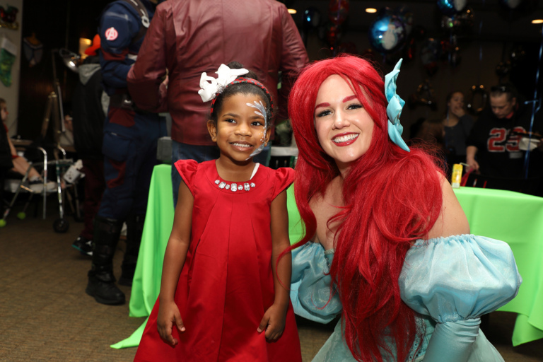 Young girl smiling with Ariel from the Little Mermaid