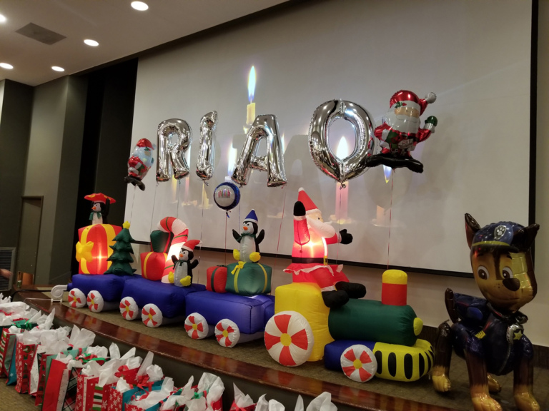 Inflatable train with Santa and penguins with gifts and balloons spelling out RIAO (Rubin Institute for Advanced Orthopedics) at the International Center for Limb Lengthening pediatric holiday party