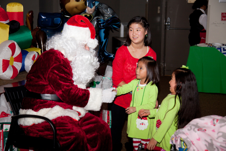 Santa talking to 3 girls at the International Center for Limb Lengthening pediatric holiday party