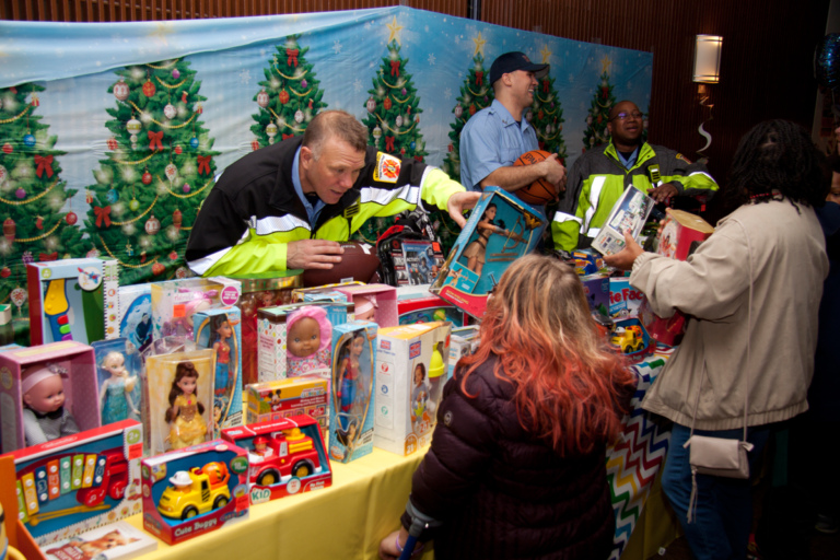 Firemen handing out toys to patients at the International Center for Limb Lengthening pediatric holiday party