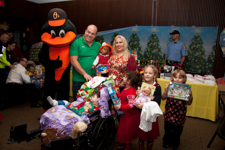 Parents with 4 young children with gifts and one sleeping child wearing casts in a wheelchair at the International Center for Limb Lengthening pediatric holiday party