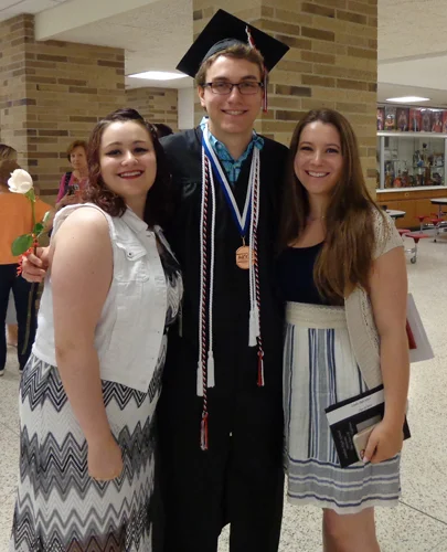 Chase at his high school graduation with his sisters