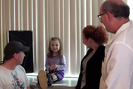 Fibular hemimelia patient with an external fixator on her leg talking to Dr. John Herzenberg at the International Center for Limb Lengthening