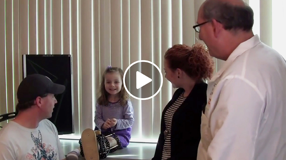 Fibular hemimelia patient with an external fixator on her leg talking to Dr. John Herzenberg at the International Center for Limb Lengthening