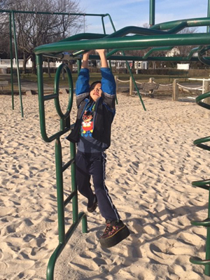 Primo with a shoe lift playing on the monkey bars