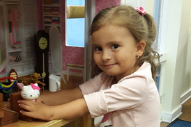 Anicka using her treated hand to play with toys