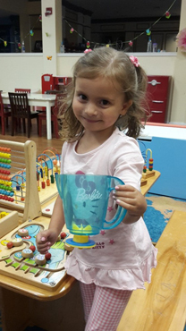 Anicka using her treated hand to hold a play pitcher