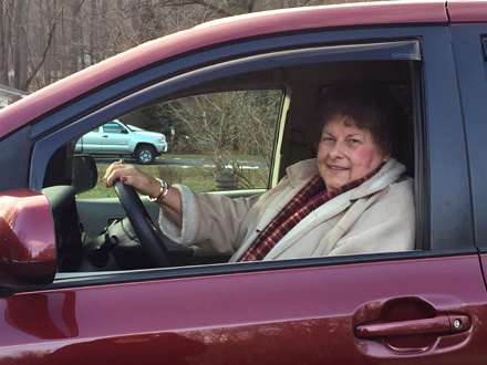 Sue in her car that has adaptive hand controls