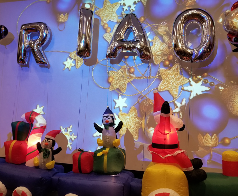 Inflatable train with Santa and penguins with gifts and balloons spelling out RIAO (Rubin Institute for Advanced Orthopedics) at the International Center for Limb Lengthening pediatric holiday party