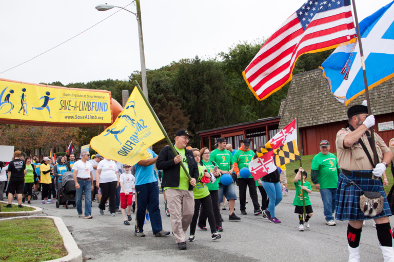 Dr. John Herzenberg holds Save-A-Limb flag during the family fun walk at Rubin Institute for Advanced Orthopedics 2017 Save-A-Limb Fund Event