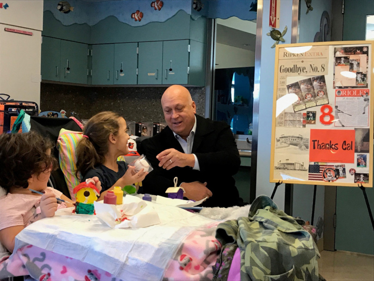 Cal Ripken gives baseball to young girl patient in wheelchair at Cal Ripken at Herman & Walter Samuelson Children