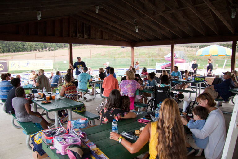 Dr. John Herzenberg addresses the crowd in an outdoor pavilion at Rubin Institute for Advanced Orthopedics 2018 Save-A-Limb Pool Party event