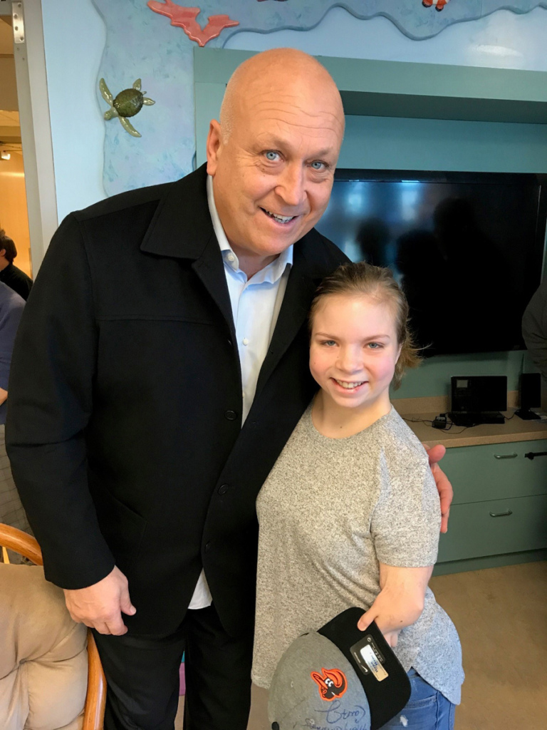 Girl patient with autographed hat poses with Cal Ripken at Herman & Walter Samuelson Children