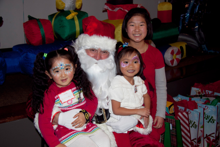 3 young girls take photo with Santa at the International Center for Limb Lengthening pediatric holiday party