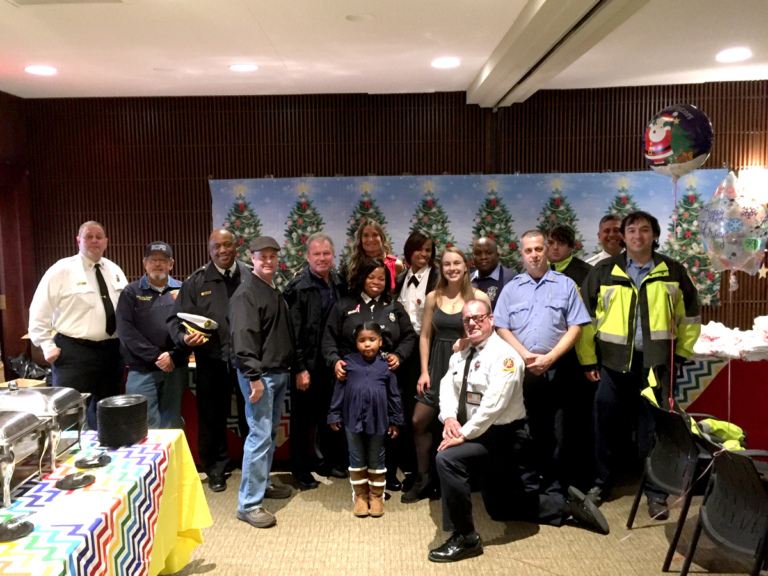 Pediatric Liaison Marilyn Richardson poses with firemen and volunteers at the International Center for Limb Lengthening pediatric holiday party