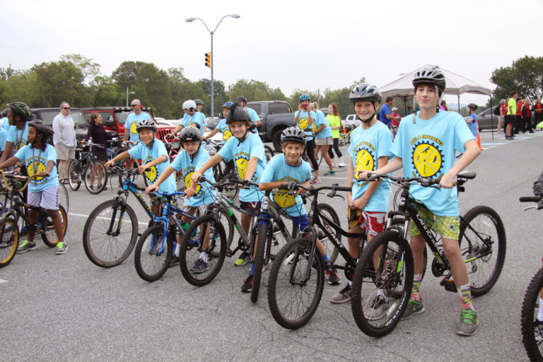 6 children in Save-A-Limb blue event shirts on bikes at Rubin Institute for Advanced Orthopedics 2016 Save-A-Limb Fund Event