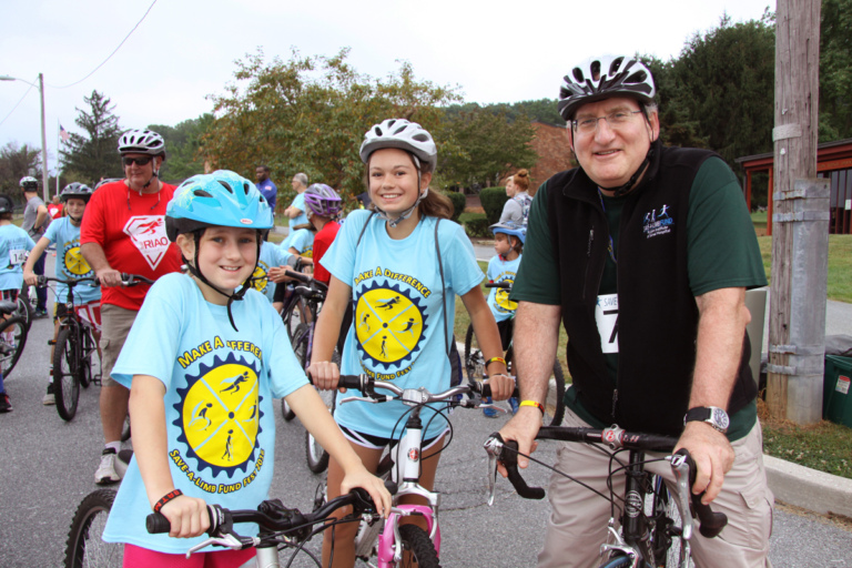 Dr. John Herzenberg on bike with 2 young girls on bikes at Rubin Institute for Advanced Orthopedics 2016 Save-A-Limb Fund Event