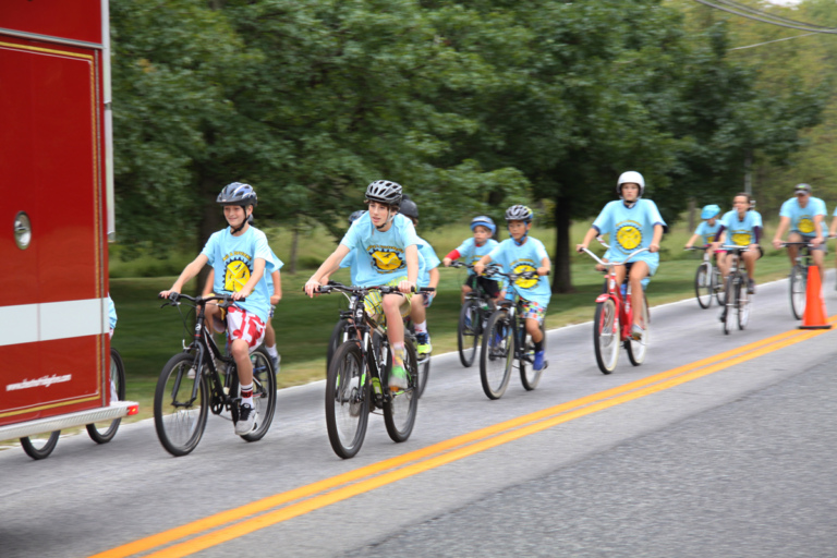 Several bike riders follow behind fire truck at Rubin Institute for Advanced Orthopedics 2016 Save-A-Limb Fund Event