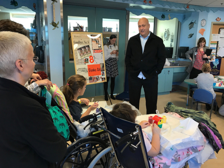 Cal Ripken talks to 2 young girl patients in wheelchairs at Cal Ripken at Herman & Walter Samuelson Children