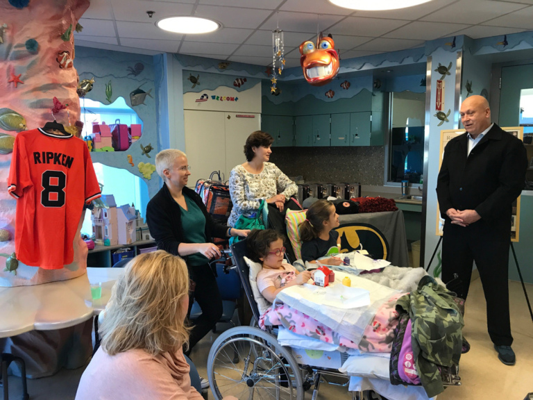 Cal Ripken talks to 2 young girl patients in wheelchairs and mothers at Cal Ripken at Herman & Walter Samuelson Children