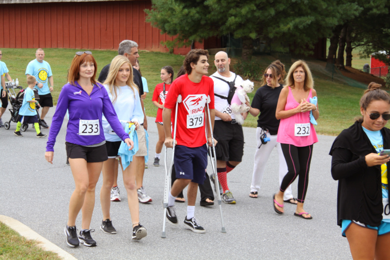 Boy with crutches walking among other walkers in the “Make a Difference Walk” at Rubin Institute for Advanced Orthopedics 2016 Save-A-Limb Fund Event