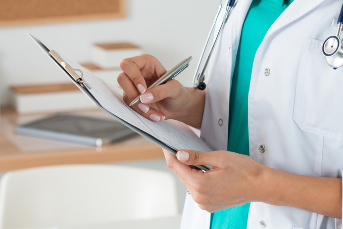 Closeup of doctor filling out patient registration form during first visit to the International Center for Limb Lengthening