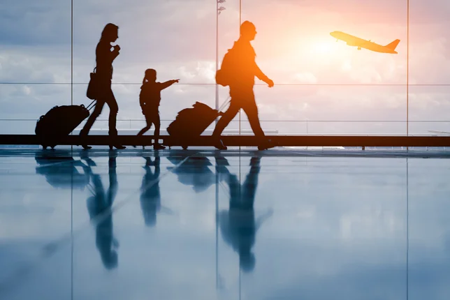 Silhouette of a family in an airport preparing to board an airplane