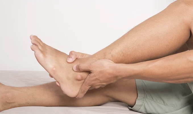 Man with foot and ankle arthritis holding his ankle