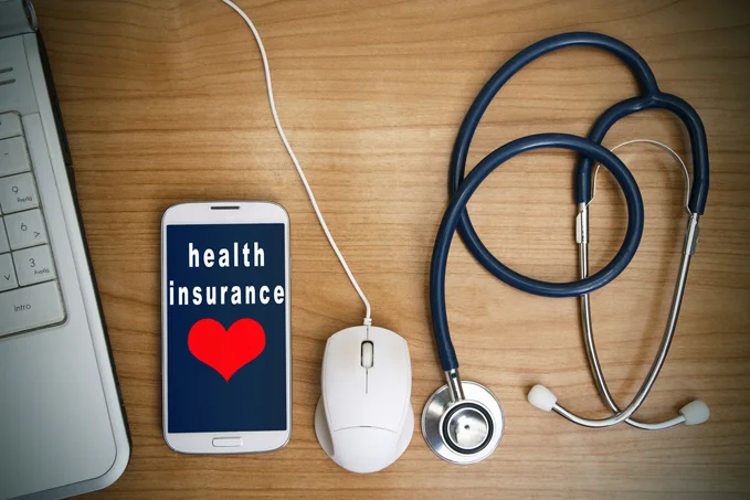 Health insurance on a tablet with a computer mouse and a stethoscope