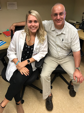 Emily as adult in white coat with Dr. Shawn Standard while doing PA clinical rotation at International Center for Limb Lengthening