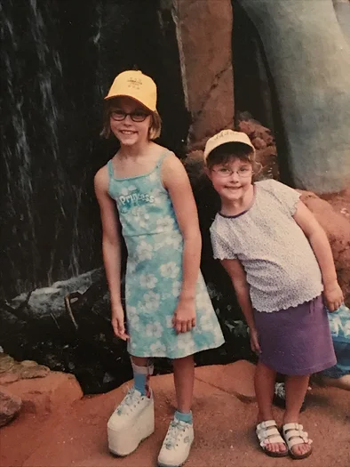 Emily as a young girl wearing a large shoe lift with another girl