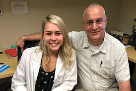 Emily as adult in white coat with Dr. Shawn Standard while doing PA clinical rotation at International Center for Limb Lengthening