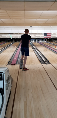 Gary bowling while wearing a walking boot