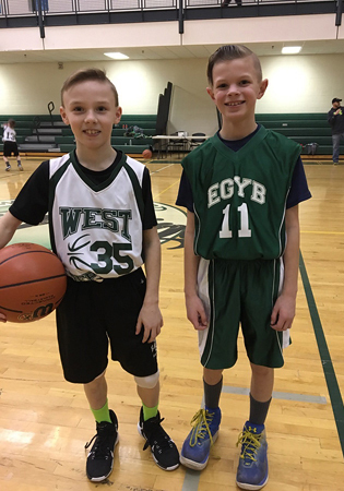 Jeffrey in a basketball uniform with a member of the opposing team holding a basketball