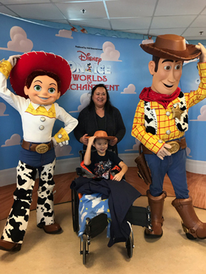 Primo in a wheelchair and his mom enjoying meeting Disney on Ice Toy Story characters visiting Sinai Hospital pediatric patients