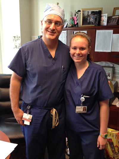 Dr. Shawn Standard with a student in scrubs as part of the physician shadowing program