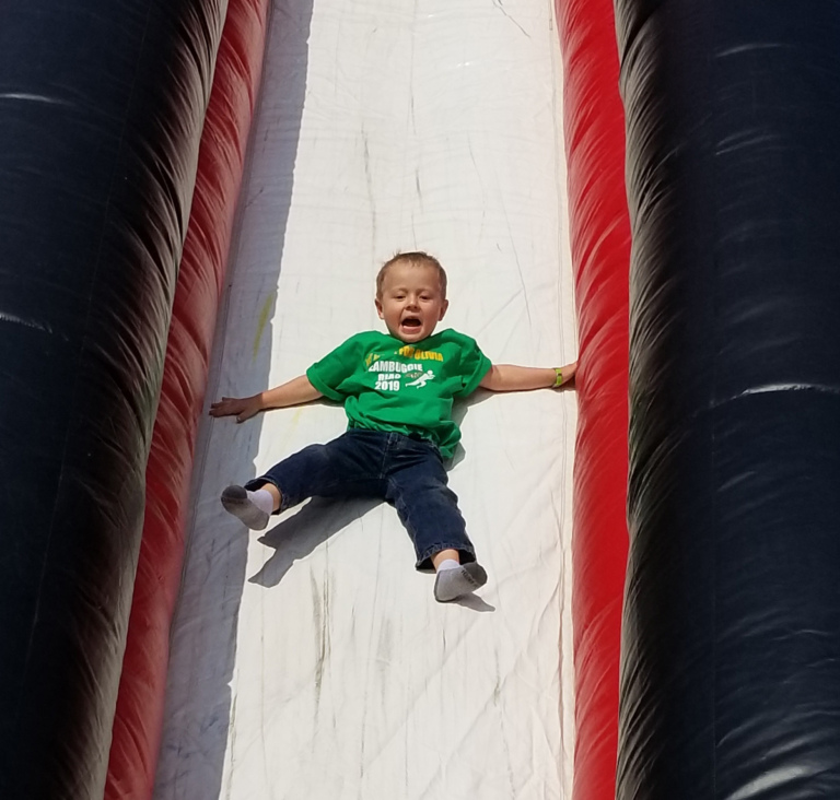 Close up of young child sliding down the giant inflatable slide