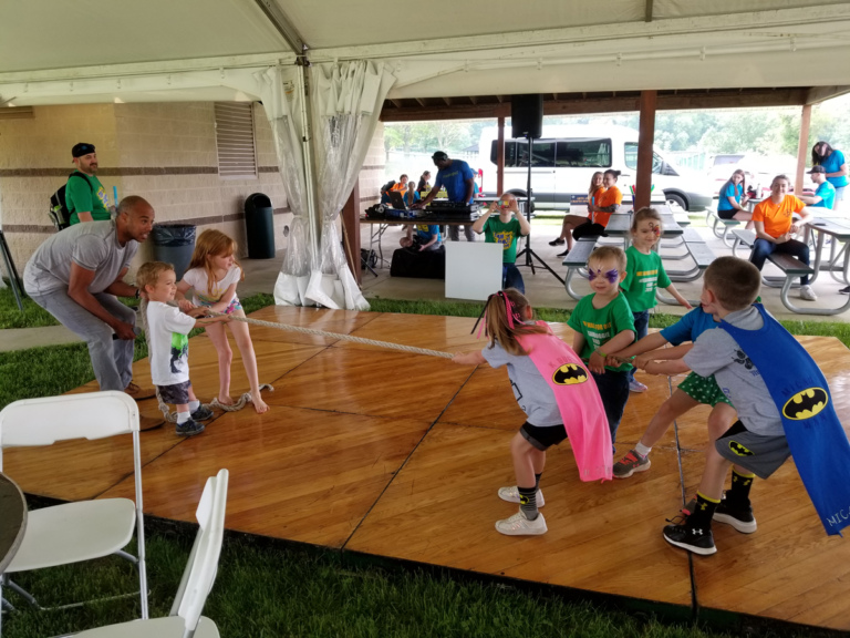 Kids playing tug of war on the dance floor under the tent