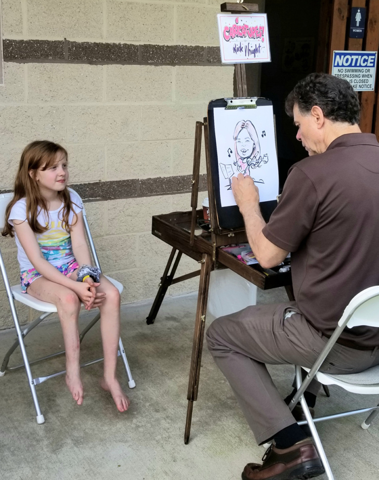 A young patient sitting while an artist draws her caricature