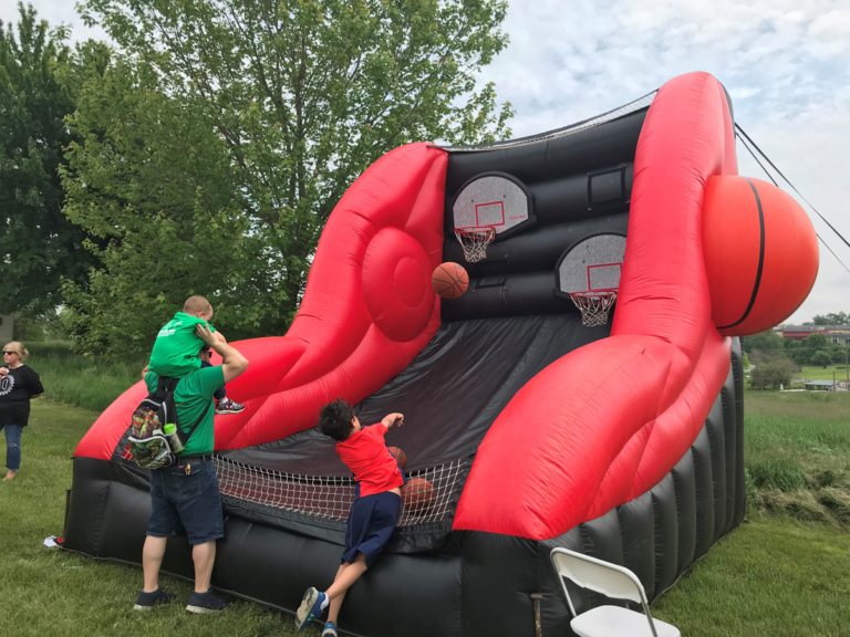 People playing giant inflatable basketball net game