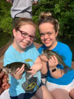 2 young women patients holding up fish they caught