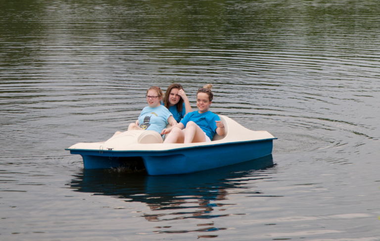 Three young women paddle boating