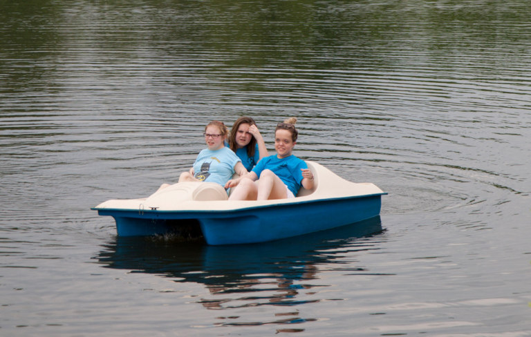 Three young women paddle boating