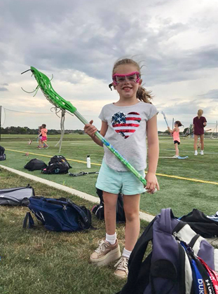 Charlotte dressed in gear for Lacrosse camp with a shoe lift