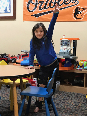 Gracie wearing a leg brace playing at the Hackerman-Patz House on Sinai Hospital's campus