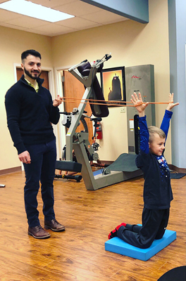 Jadon doing physical therapy with resistance bands