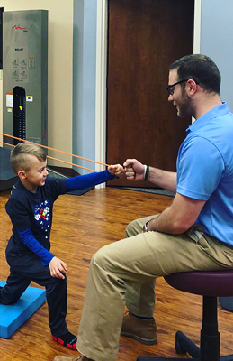 Jadon doing physical therapy with resistance bands