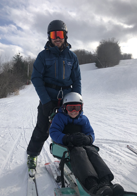 Jadon adaptive skiing on a snowy ski slope