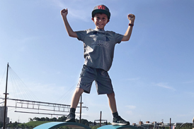 Jadon posing in a champion stance atop a large metal heart sculpture at Baltimore’s Inner Harbor